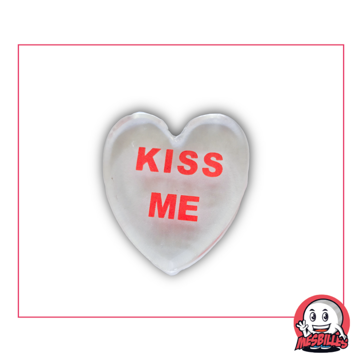 Foto einer flachen, mattierten Murmel in Herzform, 3 cm, mit der roten Aufschrift „KISS ME”, einzeln erhältlich im MesBilles-Shop.